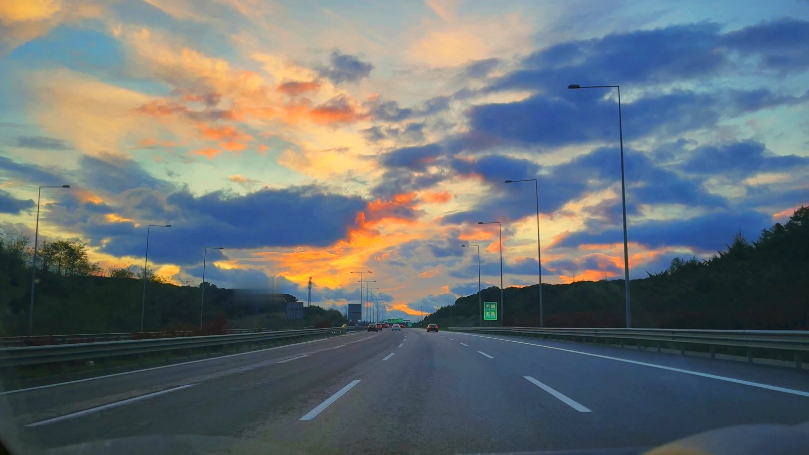 Poster frame of the JL Marine Transport film: the highway at golden hour from the cab